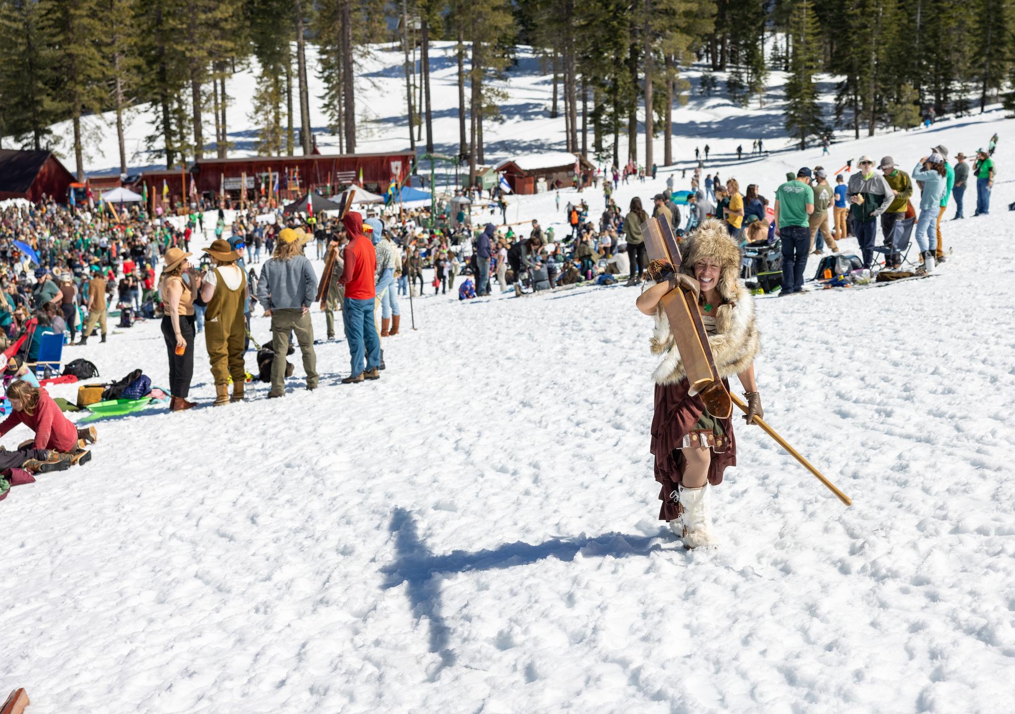 A participant hikes back to the top of the slope after winning her first race.
