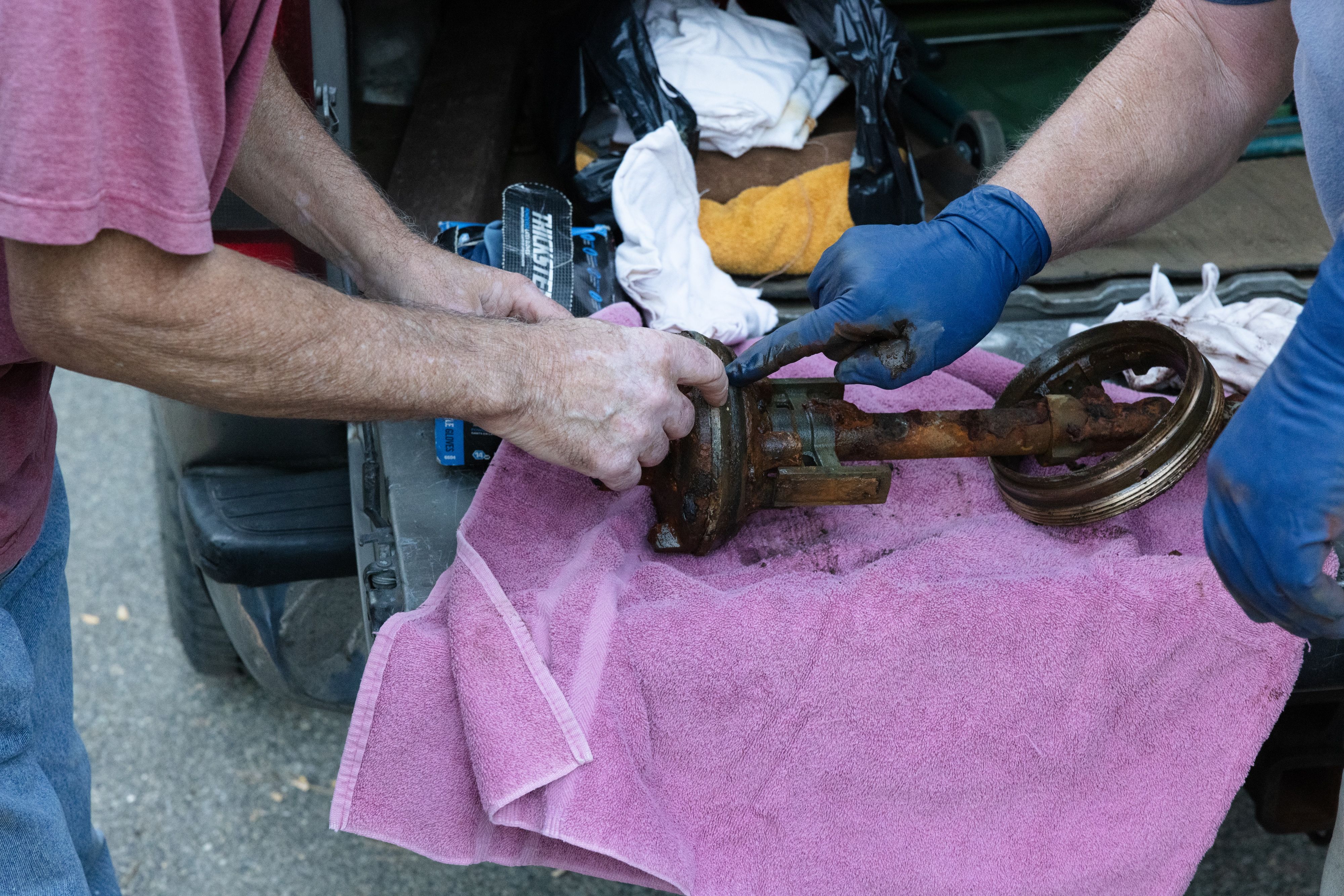 Paul Douville and Dan McNamara point out the leak-causing corrosion in the hydrant’s gasket