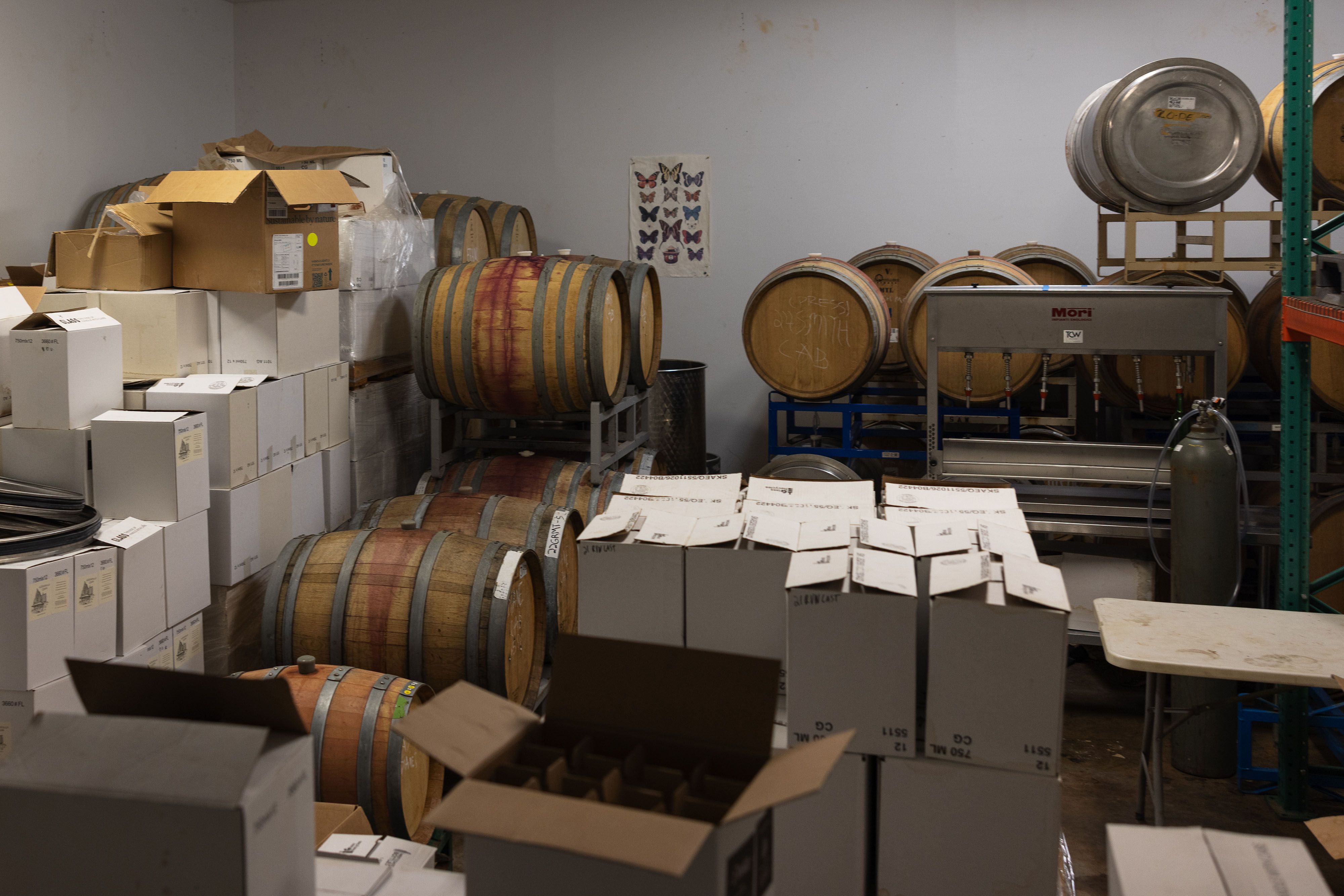 Doolan’s processing facility, including barrels of aging wine and bottles being prepared for shipment.