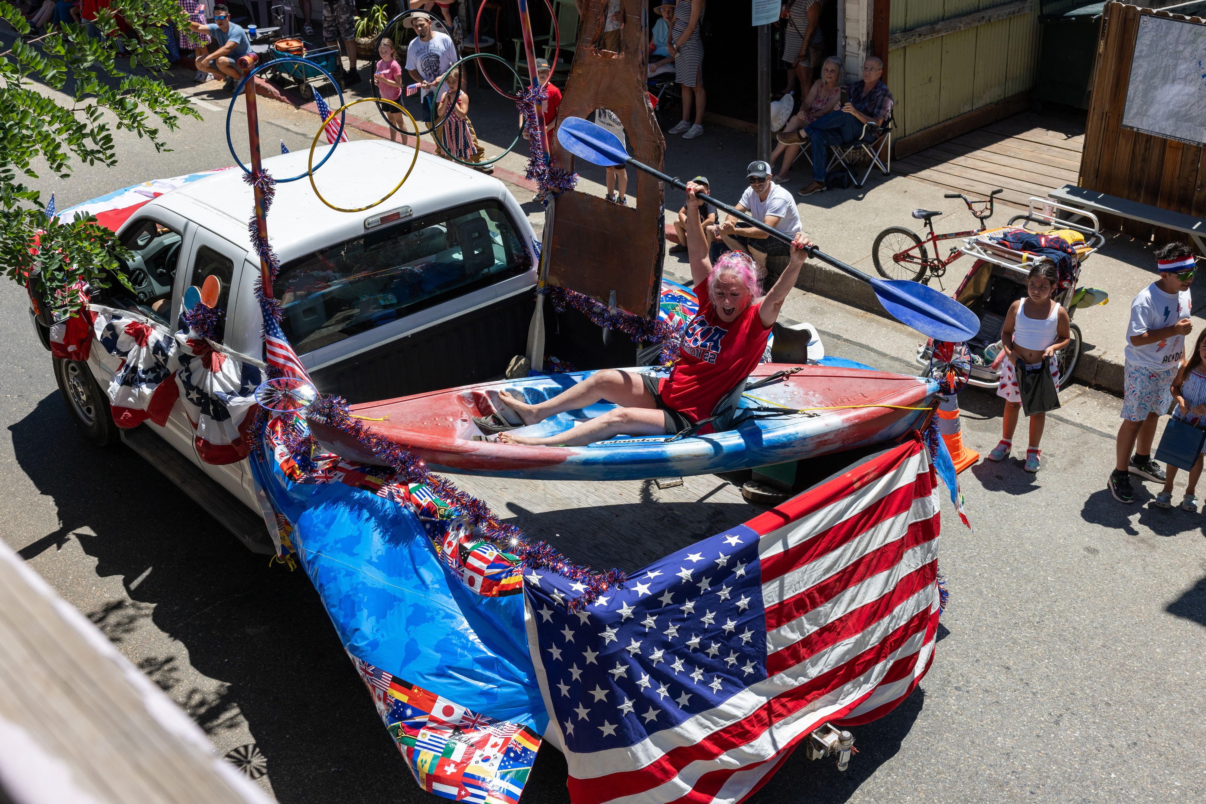 A kayaker in the back of an Olympics-themed pickup truck