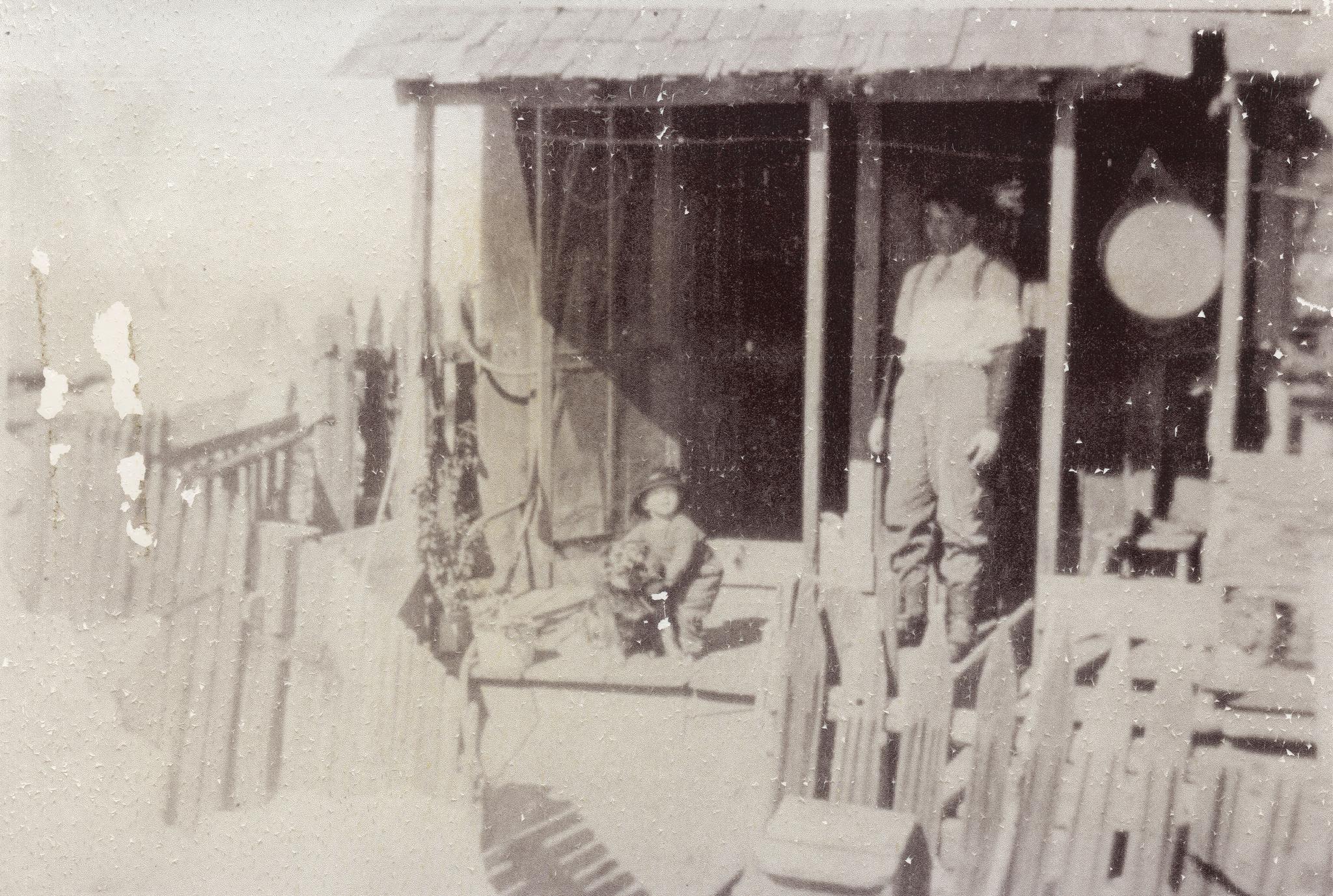 Paul Rohrig, daughter Pauline Rohrig (Russell), and dog Teddy, on the porch of
their home in Cumberland 1915. Paul Rohrig was born in Alleghany in 1878
and was the first licensed barber in Alleghany.