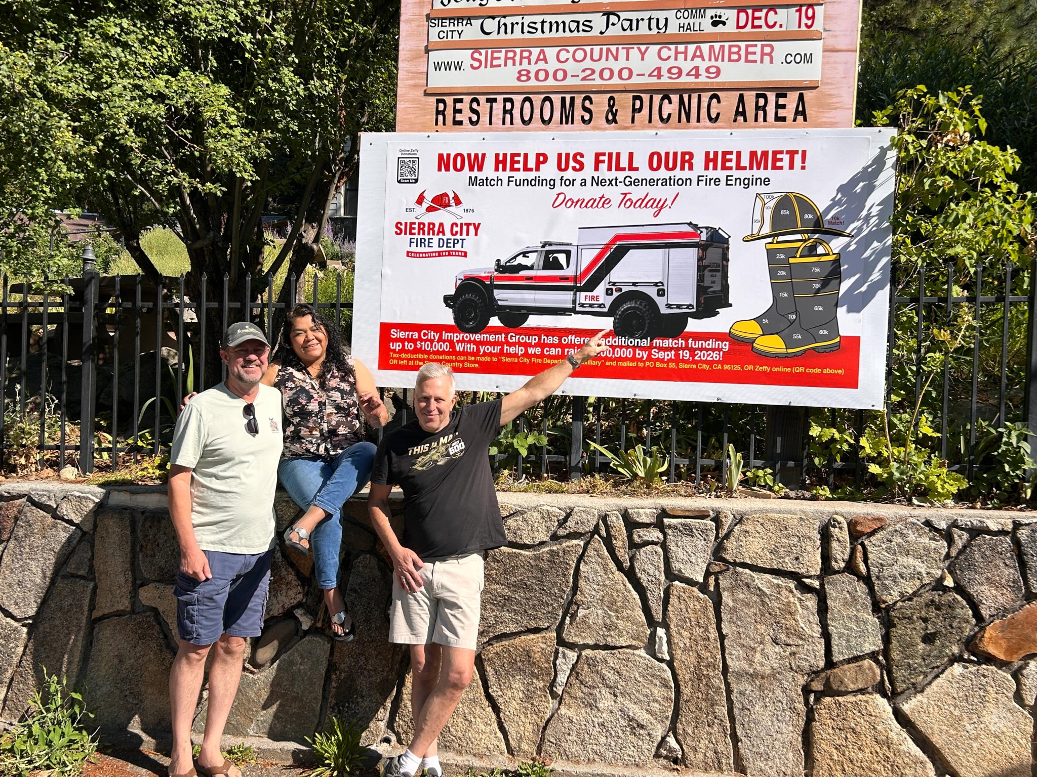 Left to right: Jim and Rosa Westfall of Sierra City Improvement Group and Eric Kubly, Deputy Chief of Sierra City Fire Department, in front of the updated Prospecting for Protection progress-tracking sign in Sierra City.