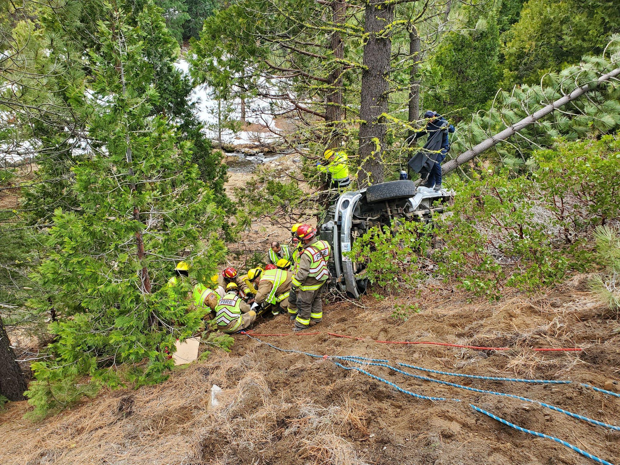 The driver of the rolled-over vehicle is extracted by first responders.
