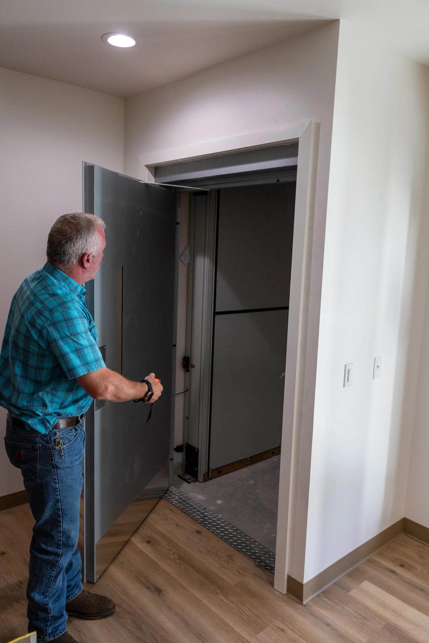 The powered lift is accessed behind a metal door next to the entrance
