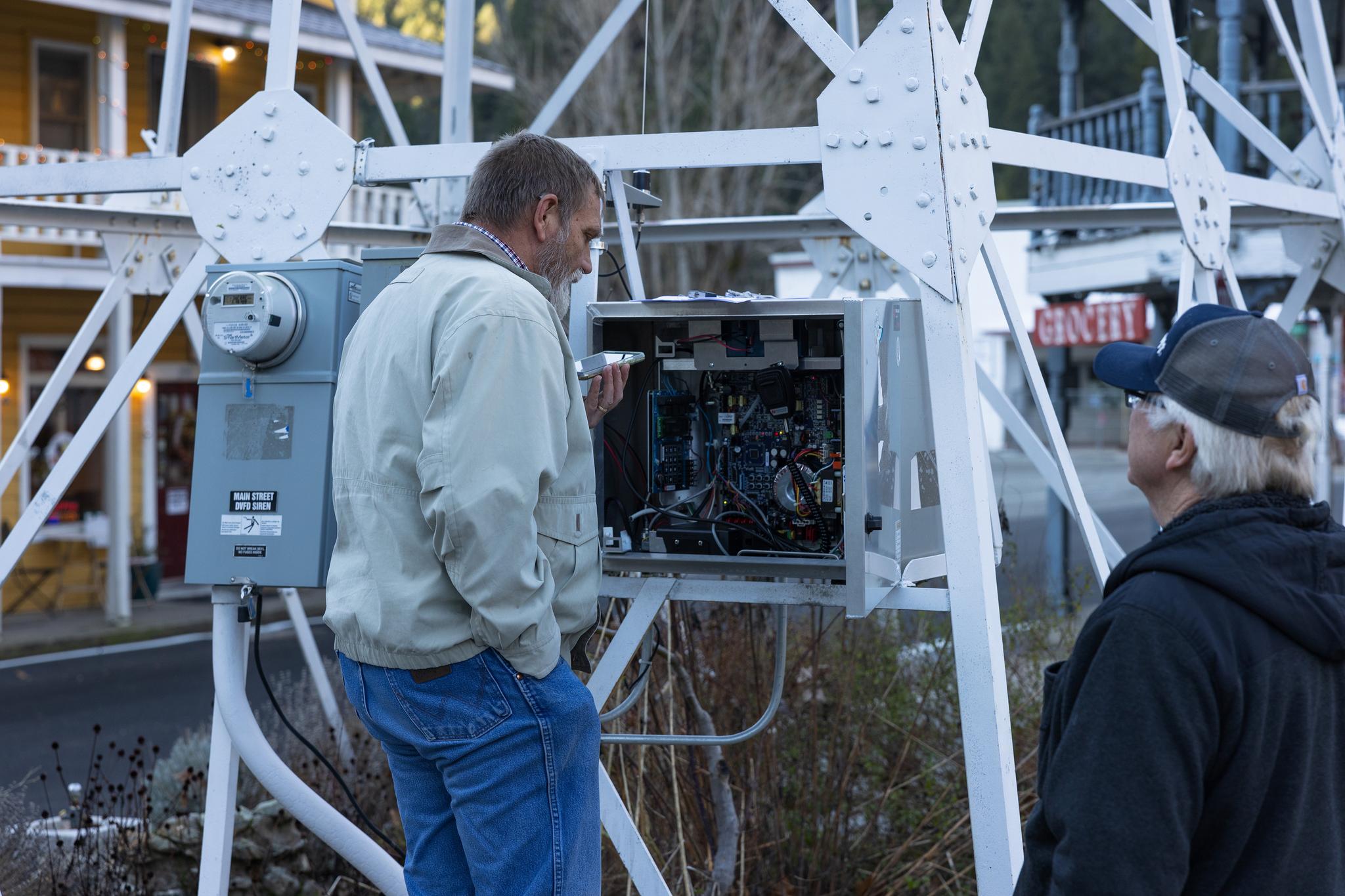 Bryan Davey attempts to get someone familiar with Downieville’s siren system on the phone.
