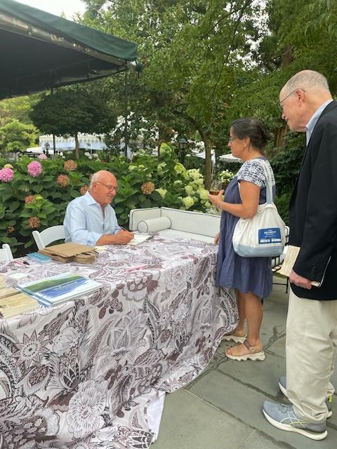 Lenny signs his book.