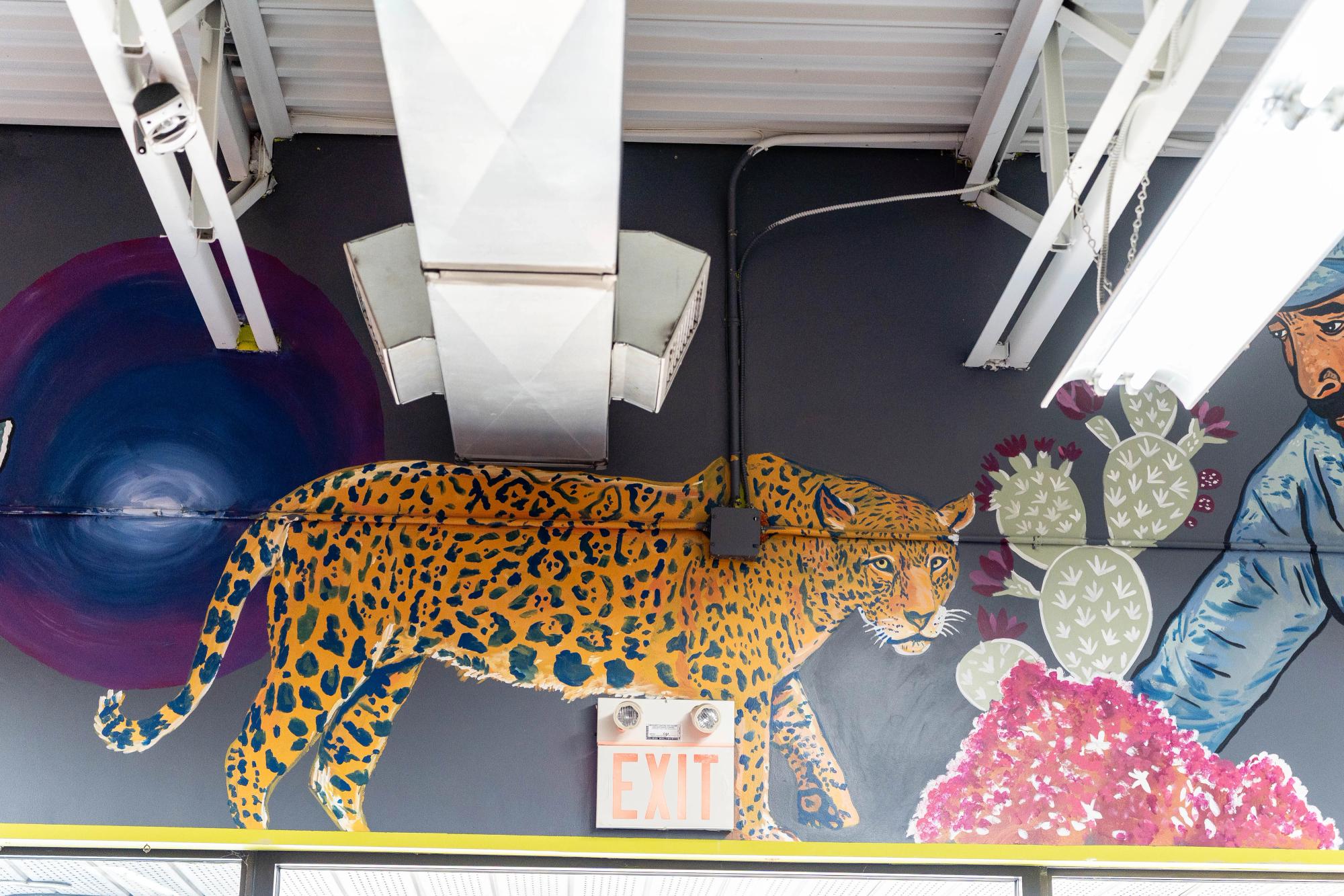 A tiger or leopard is painted on a. grey wall