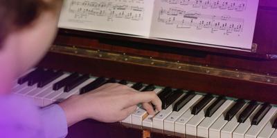 A boy who is playing chord progressions on piano