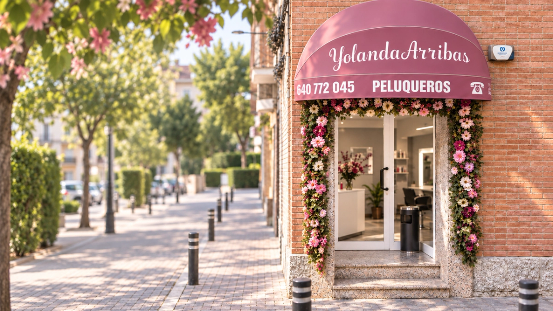 Entrada del salón Yolanda Arribas Peluqueros, con su toldo rosa y un arco de flores.