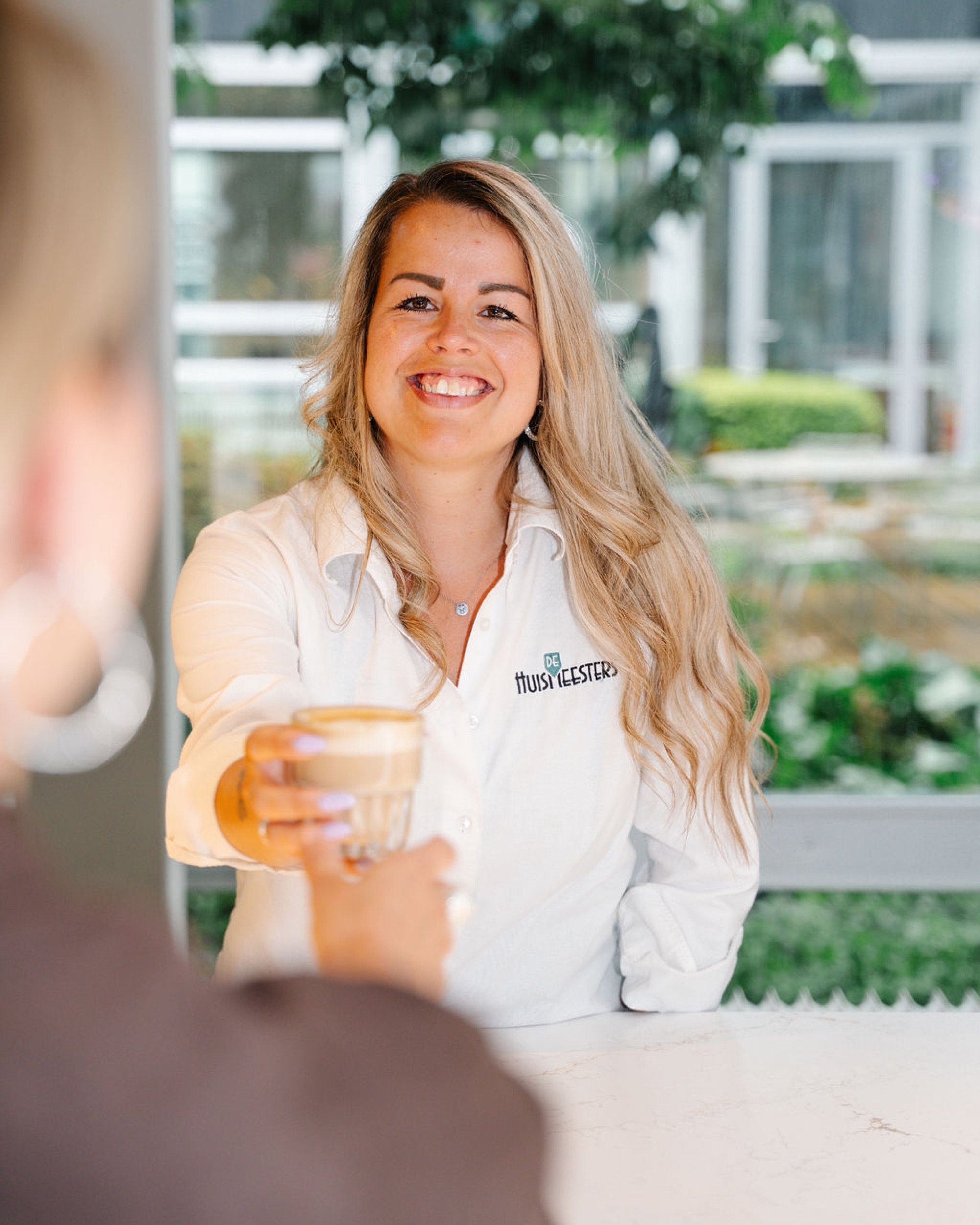 Gastvrouw van De Huismeesters serveert koffie