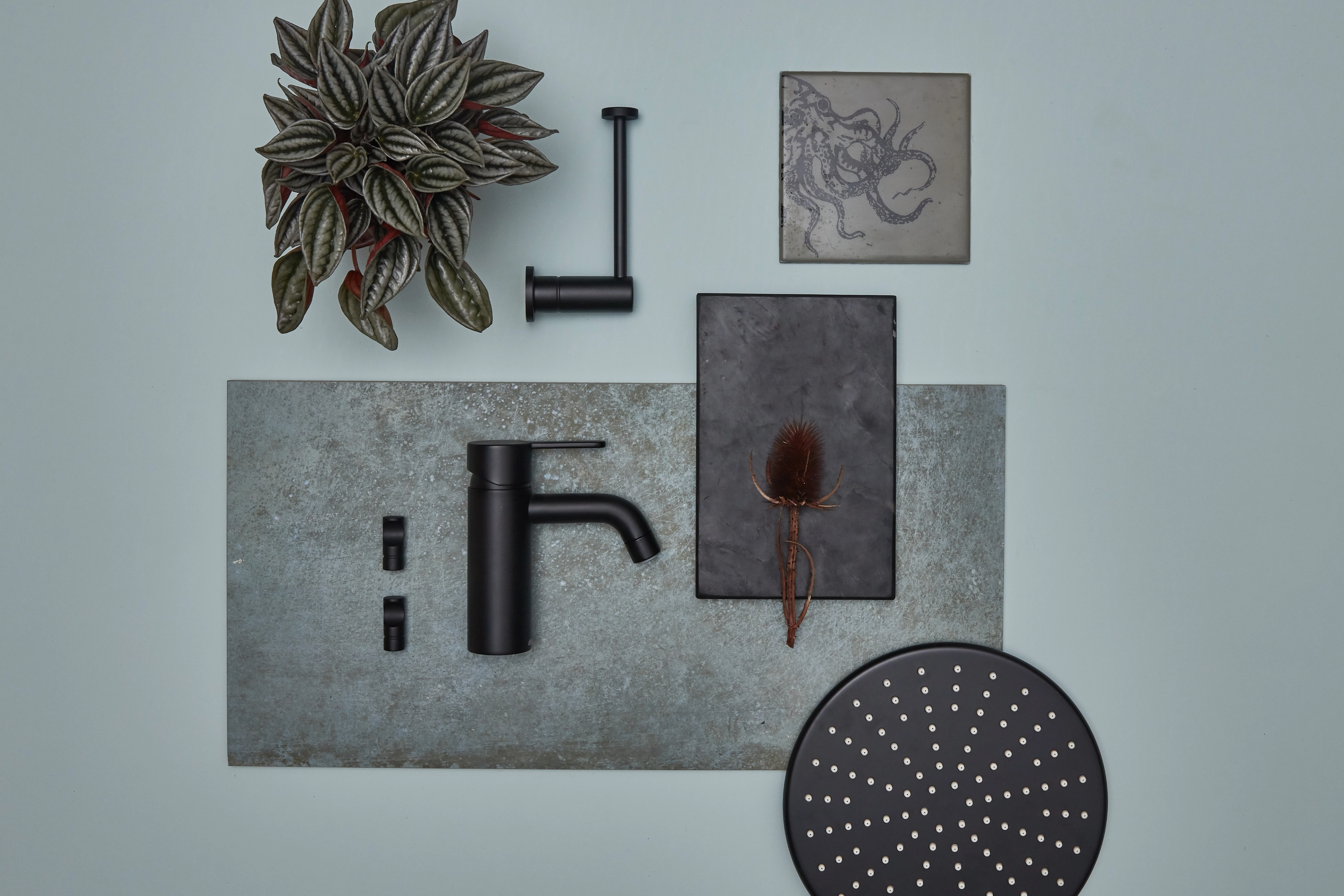 Flatlay med sorte kraner, dusjhode og materialprøver.