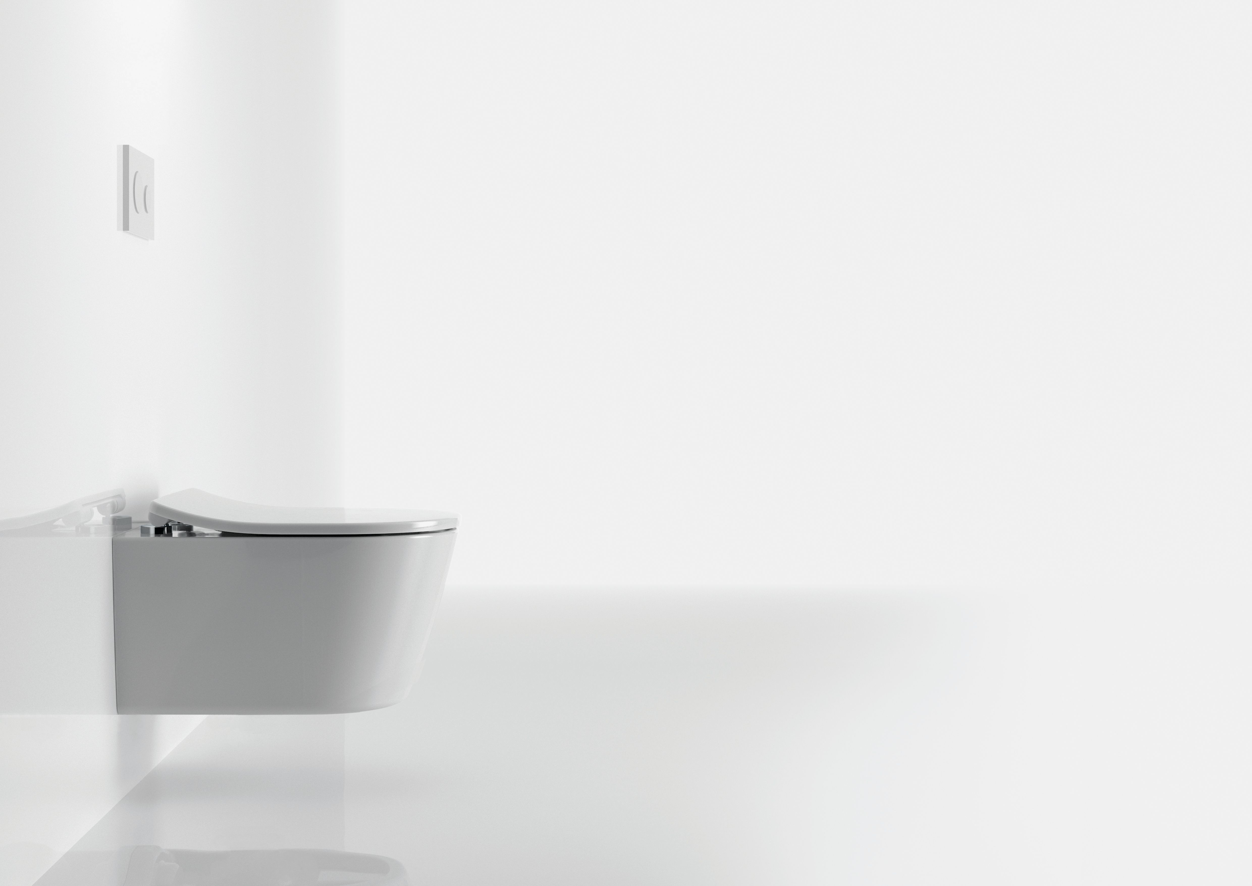 Hvitt vegghengt toalett i et lyst, minimalistisk baderom.
