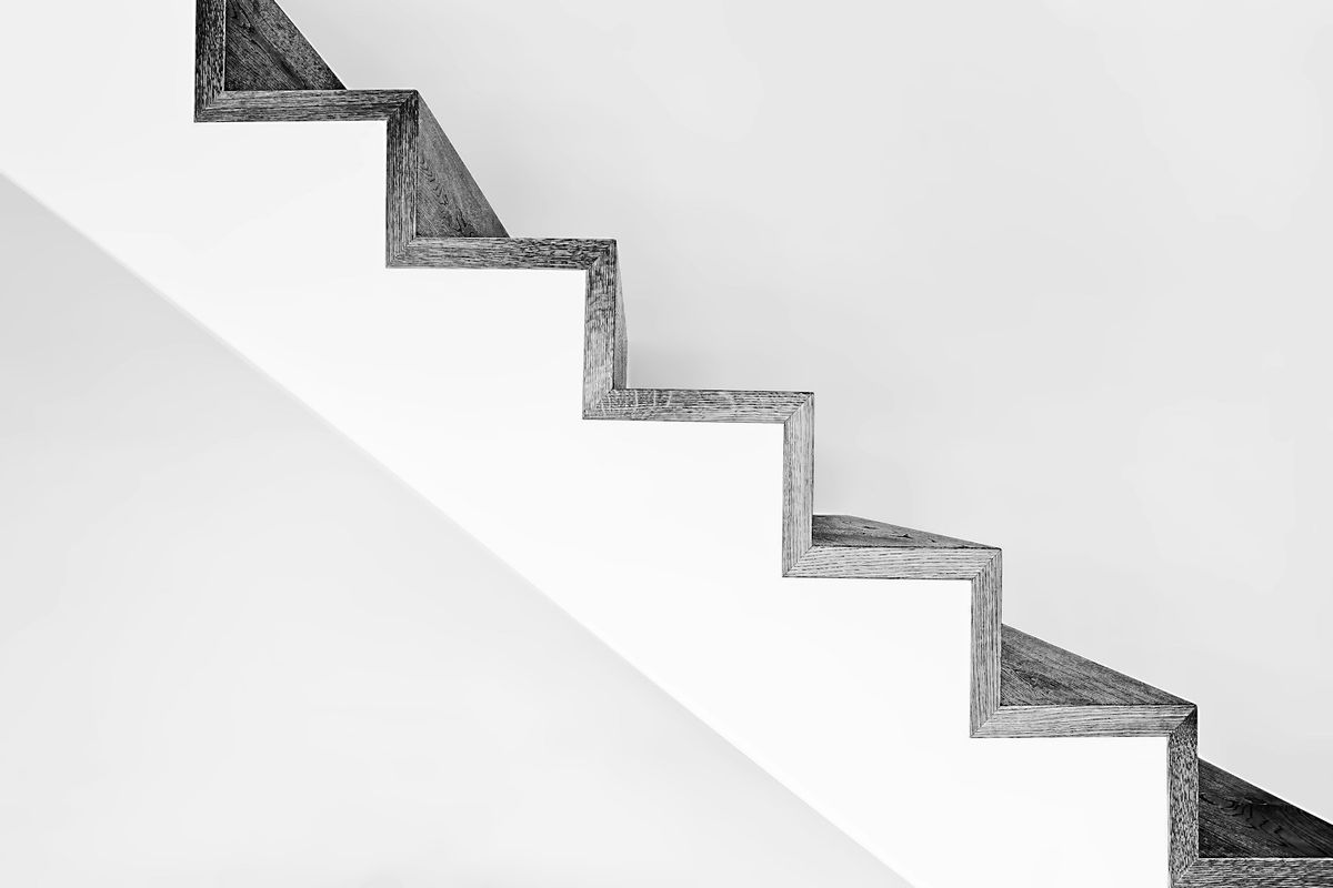 White concrete stairs with black metal railings