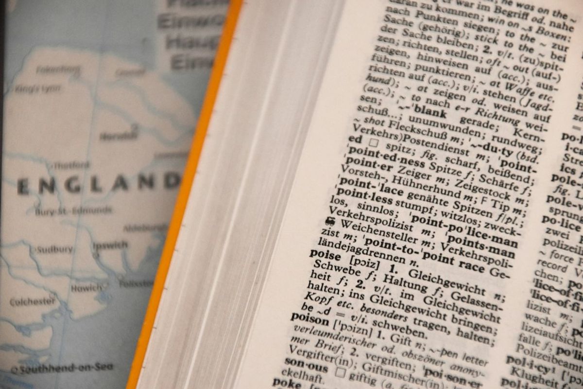 An open English dictionary lying flat, with columns of printed definitions.