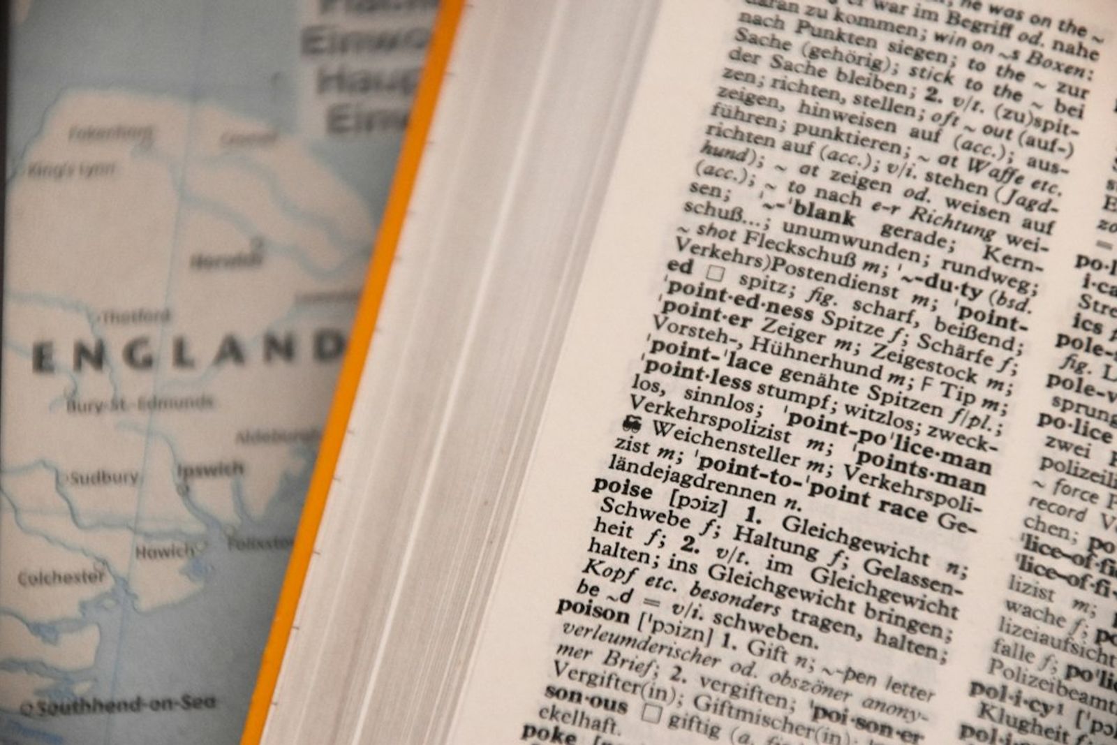 An open English dictionary lying flat, with columns of printed definitions.