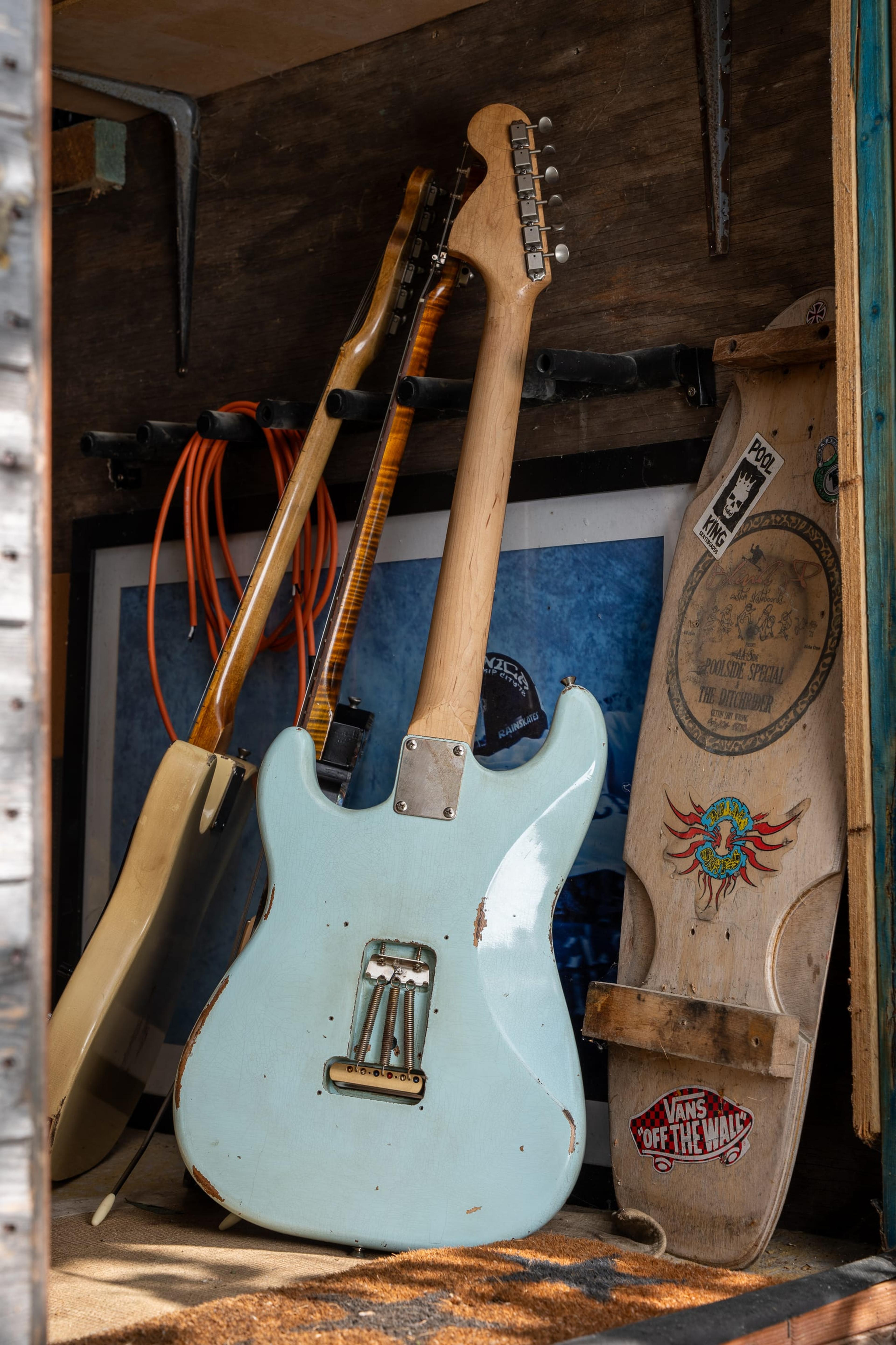 Echo, a sonic blue Strat-style guitar, in the shed doorway