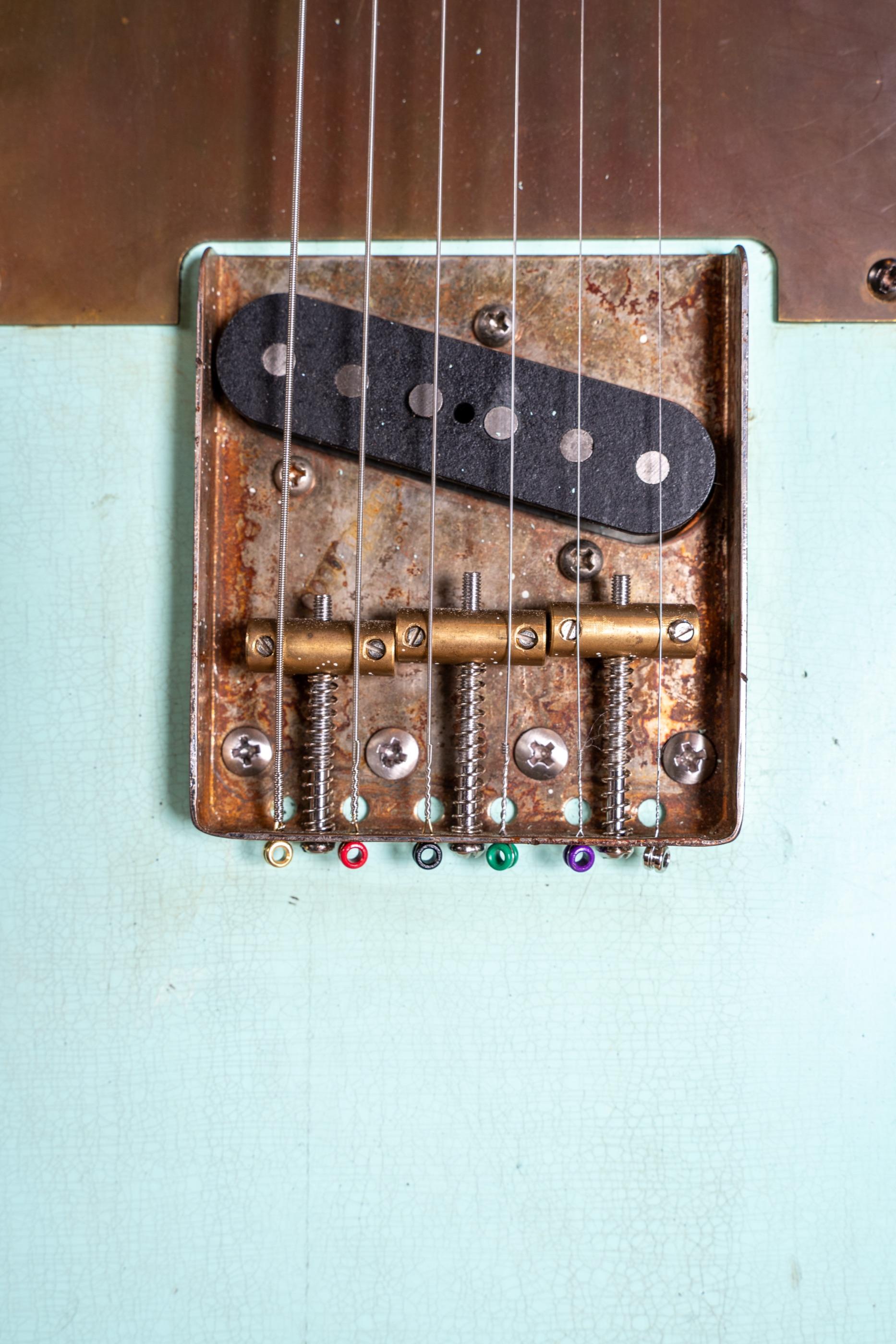 The bridge plate of the sonic blue Telecaster, three brass saddles and the ferrules