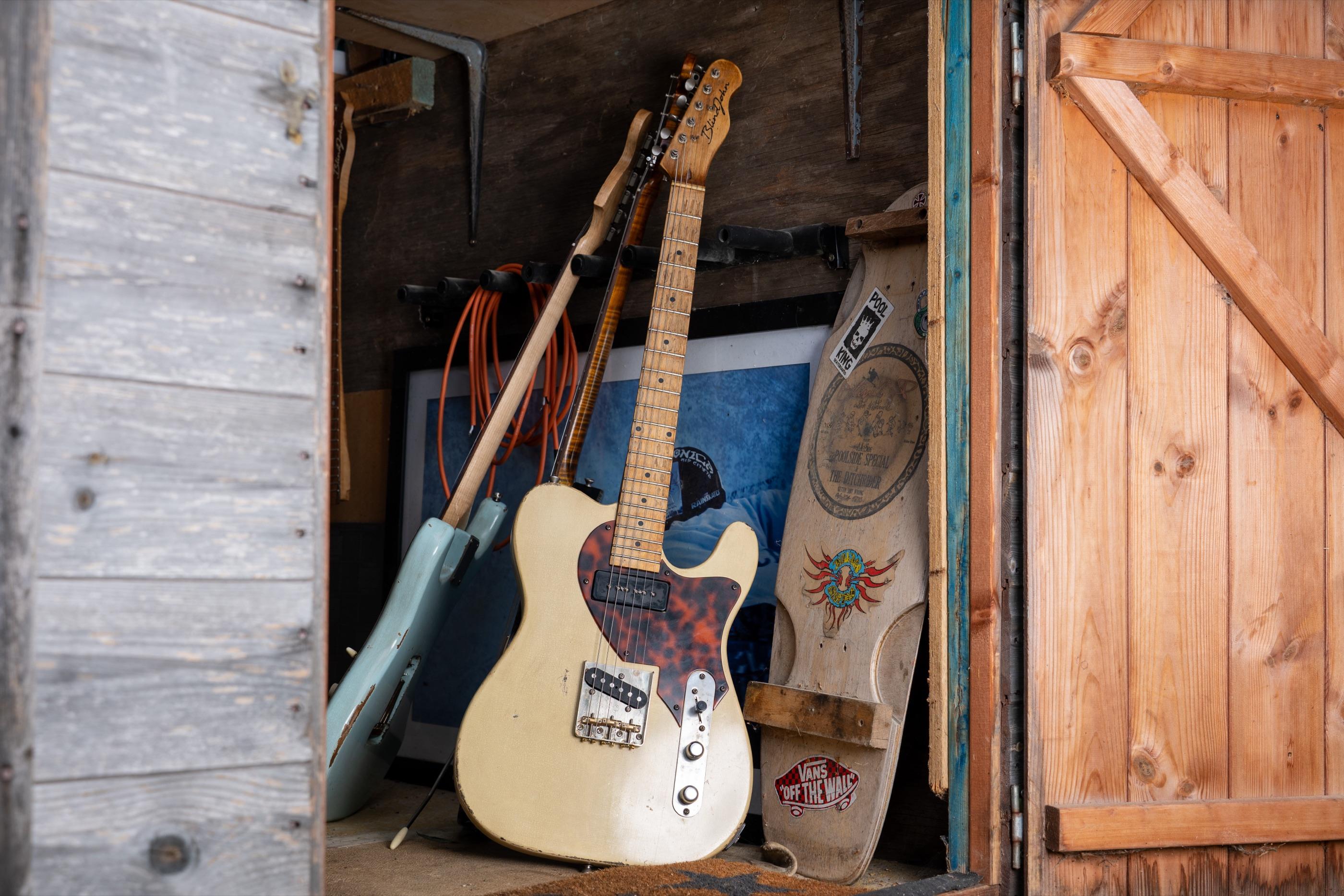 A relic'd blonde Telecaster with a tortoiseshell guard, leaning in the shed