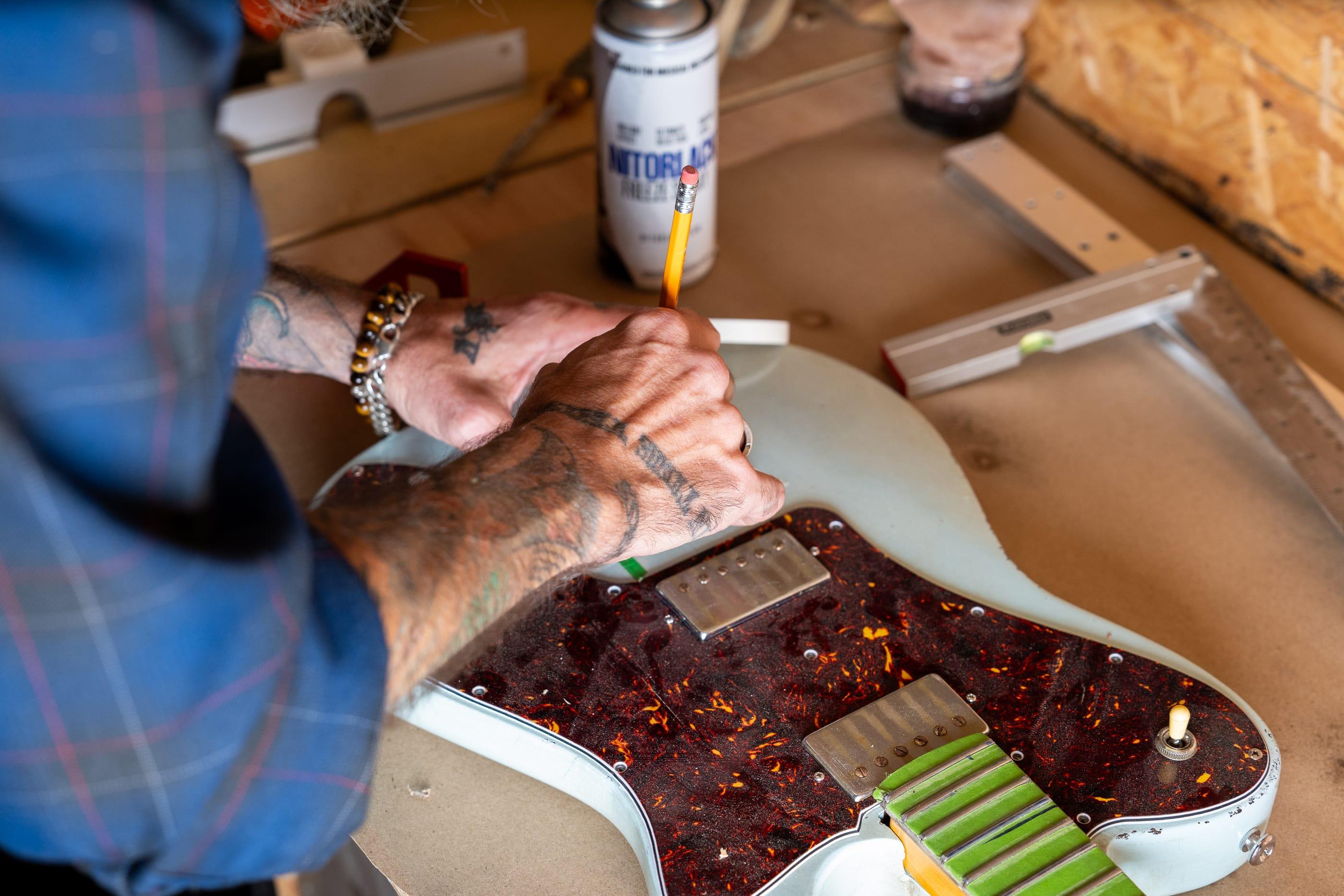 John marking out a tortoiseshell guard in pencil on a sonic blue body