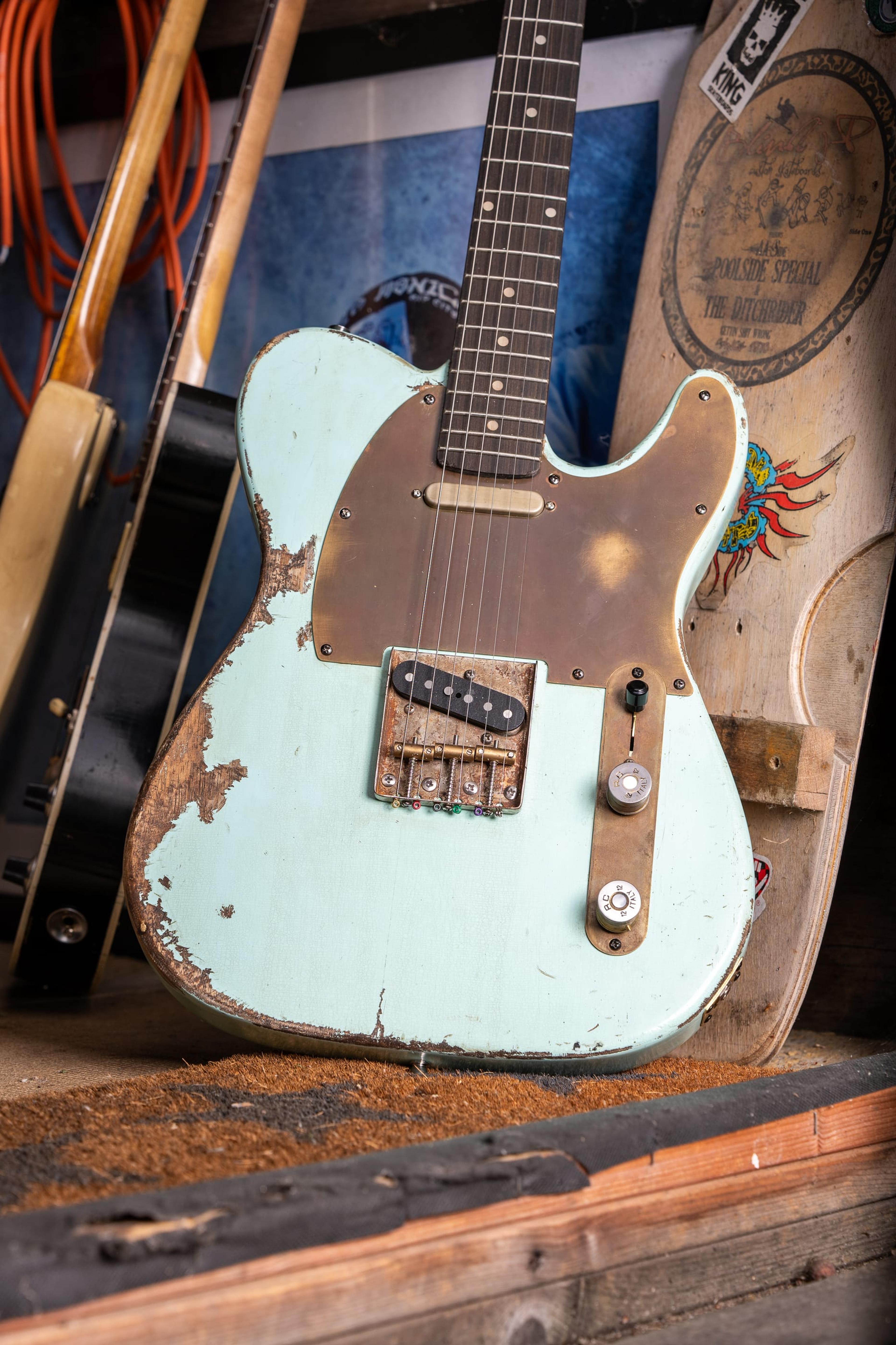 The Runaway, a pale green Tele-style guitar with a brass guard, in the shed doorway