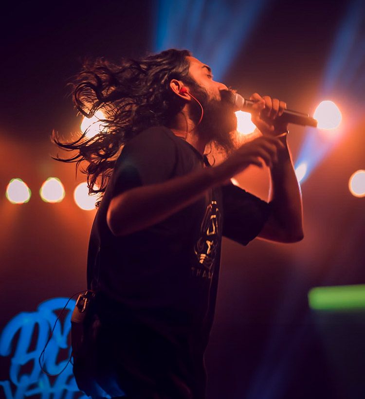 Man on stage singing into a wireless microphone