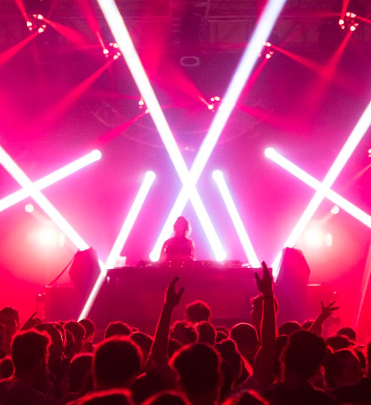 Moving heads lighting behind a DJ at festival