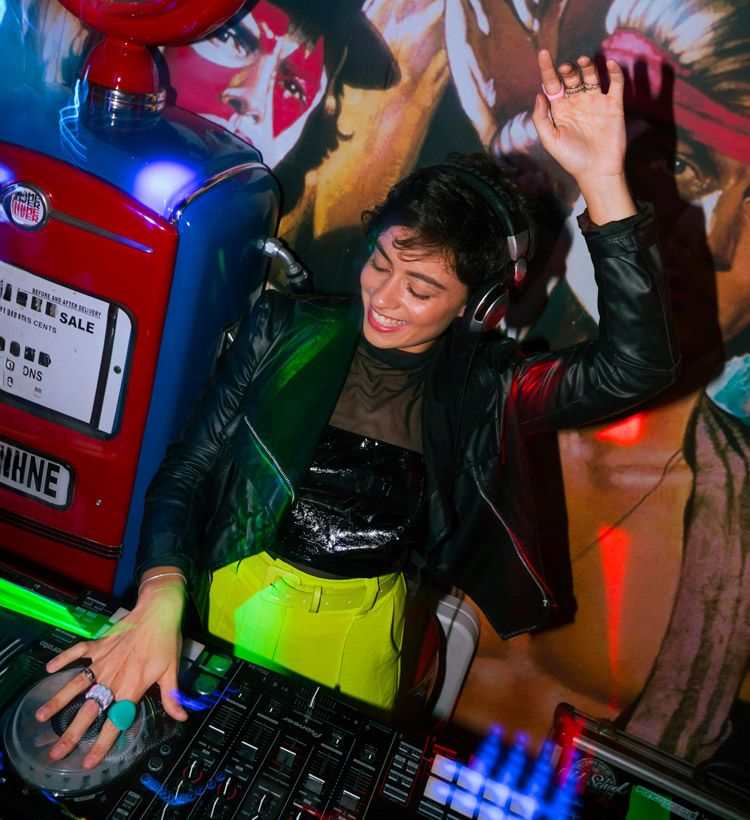 Young woman DJing on DJ controller at party