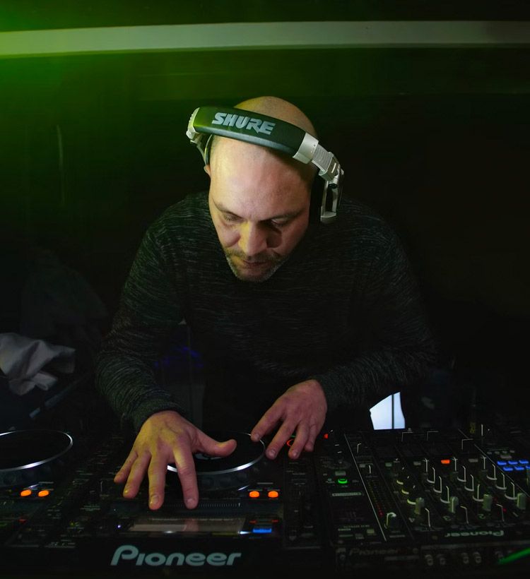 Man DJing at nightclub using Shure DJ Headphones