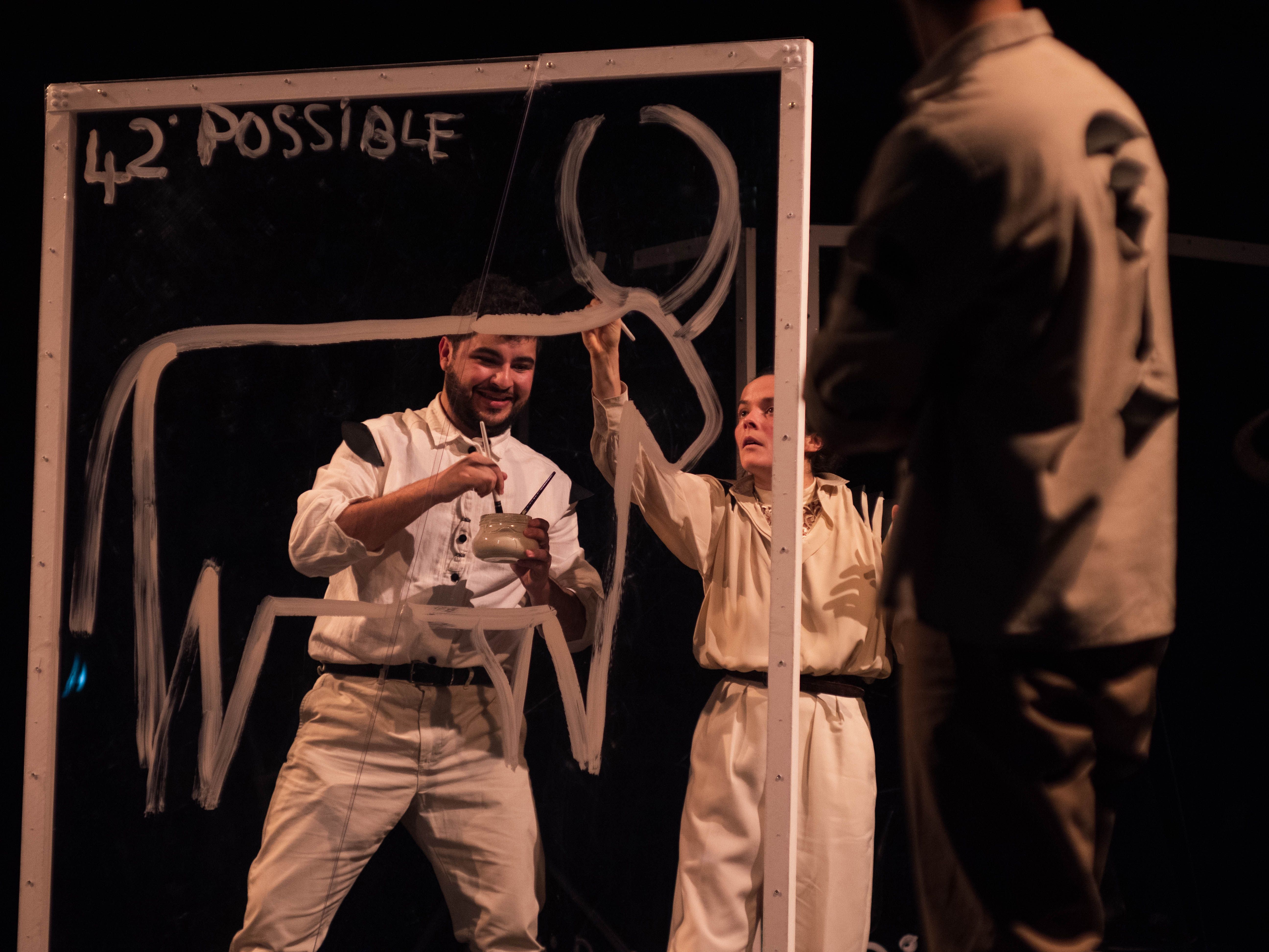 acteurs et actrices déssinant sur un tableau transparent