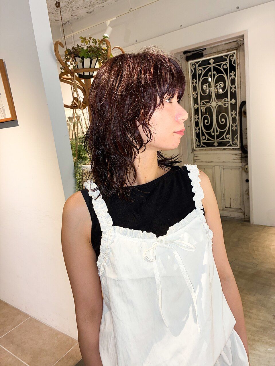 顔まわりと肩にかかる毛先に動きのあるミディアムヘアの横姿
