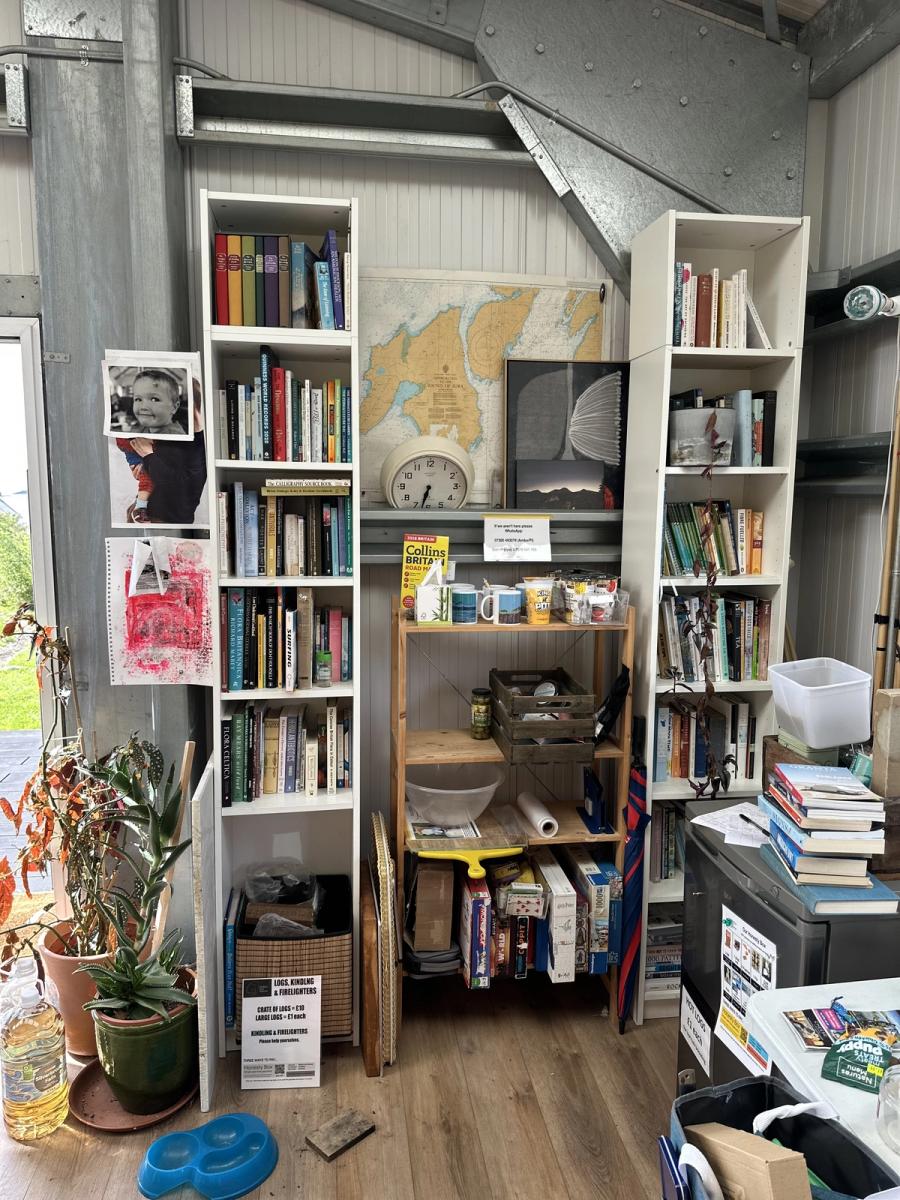 Bookshelves in the shed at Bothan Jura Retreat, Isle of Jura, with a map of the island on the wall