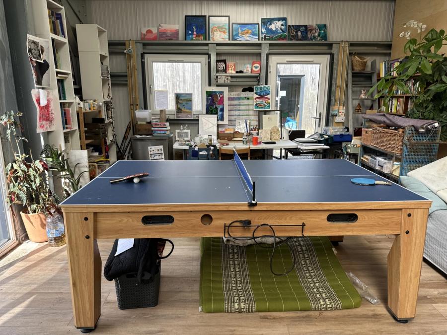 The table tennis table in the shed at Bothan Jura Retreat, Isle of Jura, with the bookshelves and noticeboard behind
