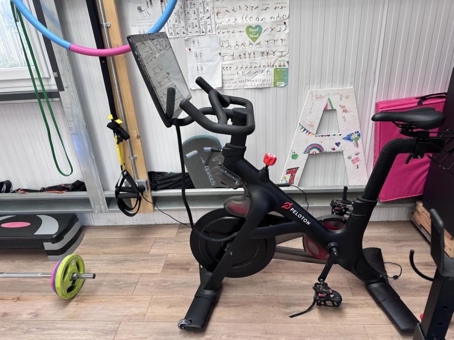 A Peloton bike in the shed gym at Bothan Jura Retreat, Isle of Jura, with the treadmill alongside