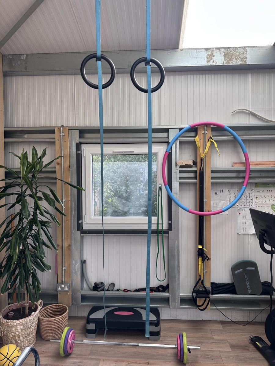 Gymnastic rings, a hula hoop and a rack of adjustable free weights in the shed gym at Bothan Jura Retreat, Isle of Jura
