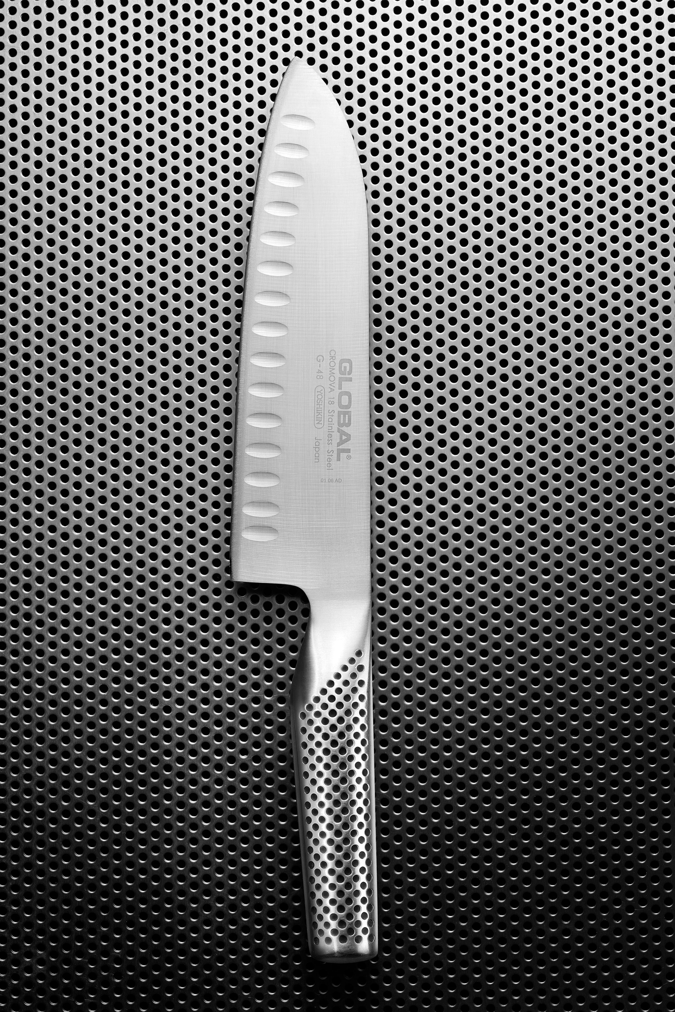 Metallisches Küchenmesser auf grafischem Lochblech