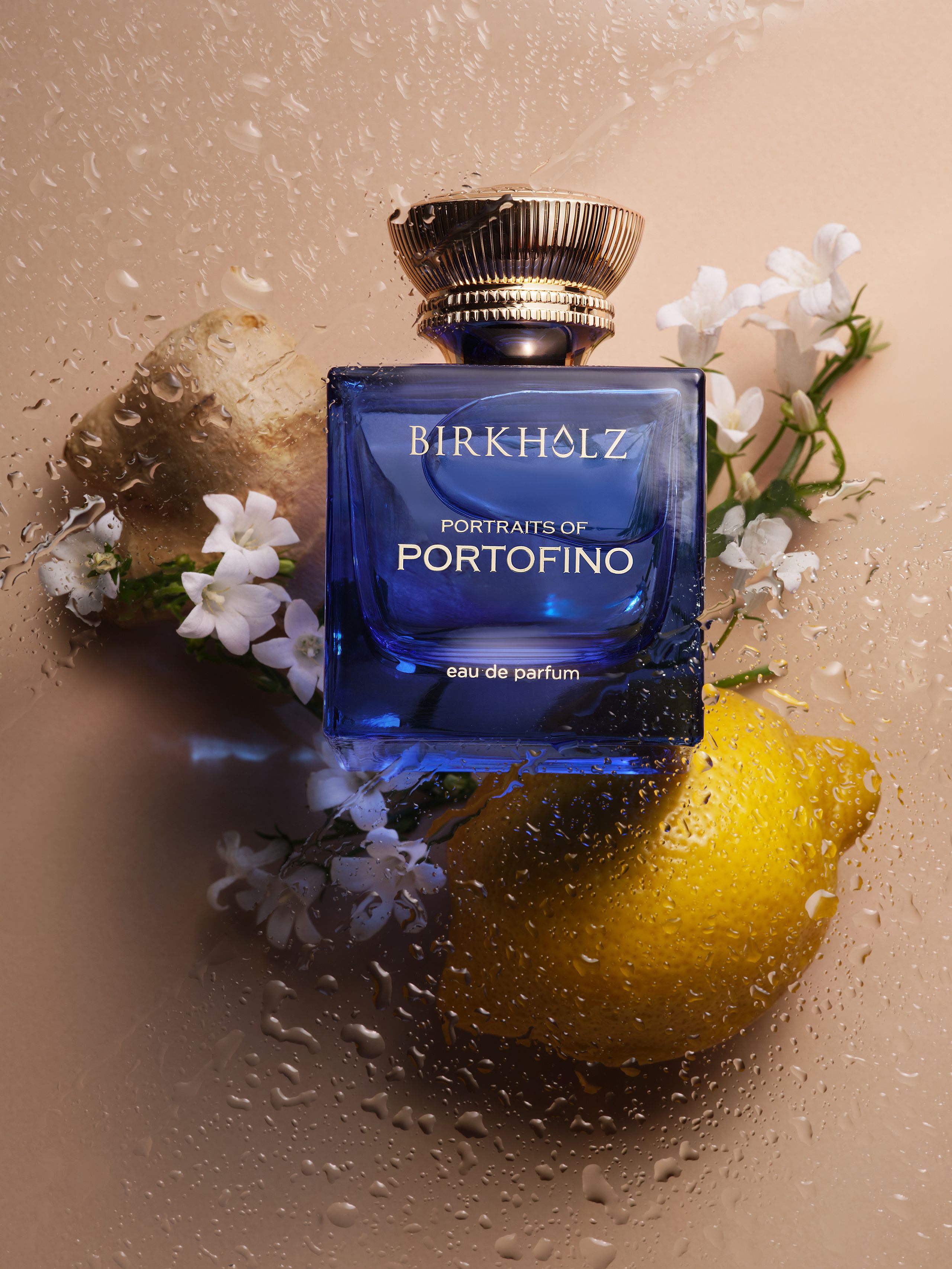 Blauer Parfumflakon mit Zitrone, Blüten und Wassertropfen