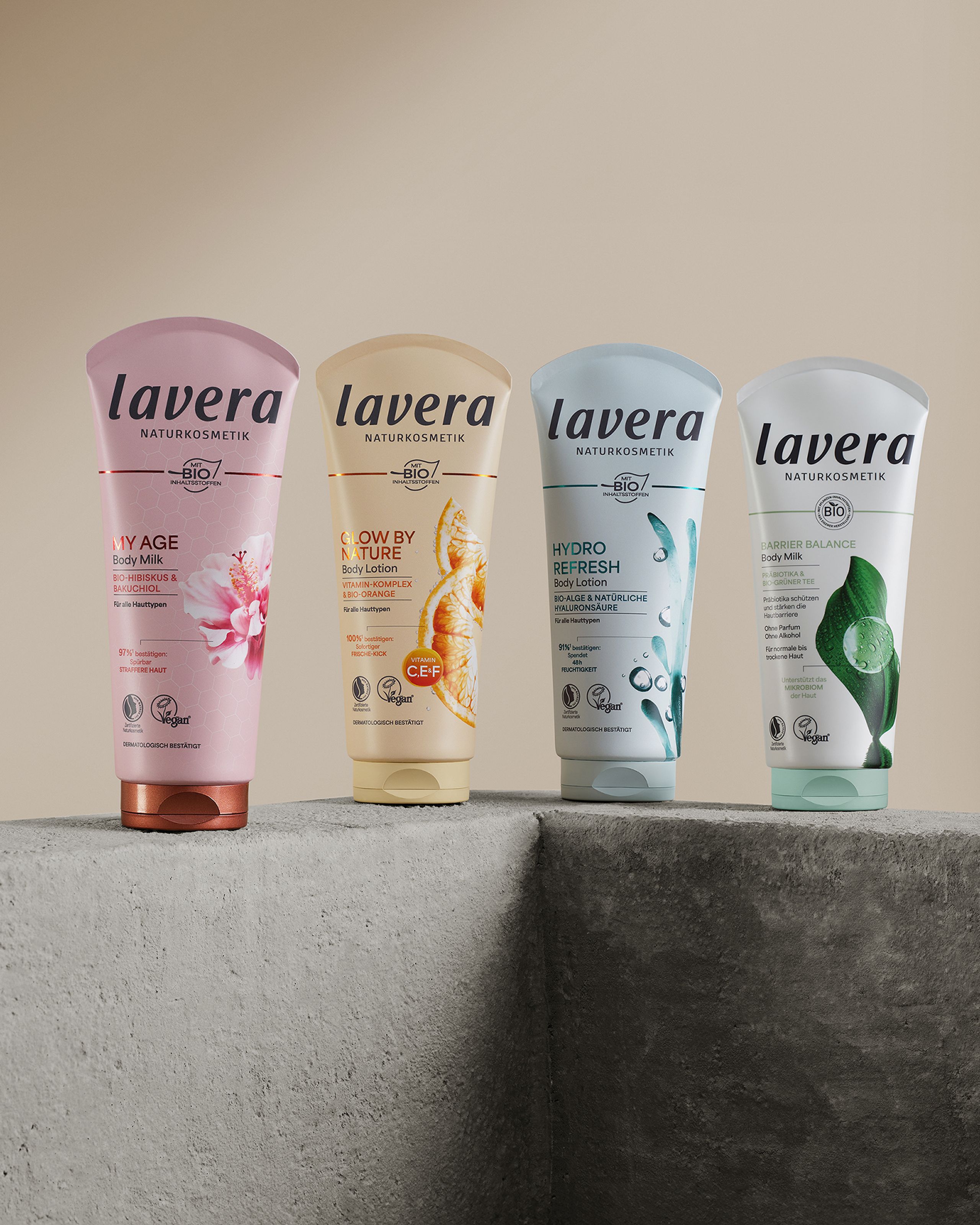 Vier Lavera-Pflegeprodukte auf einem rauen Betonsockel