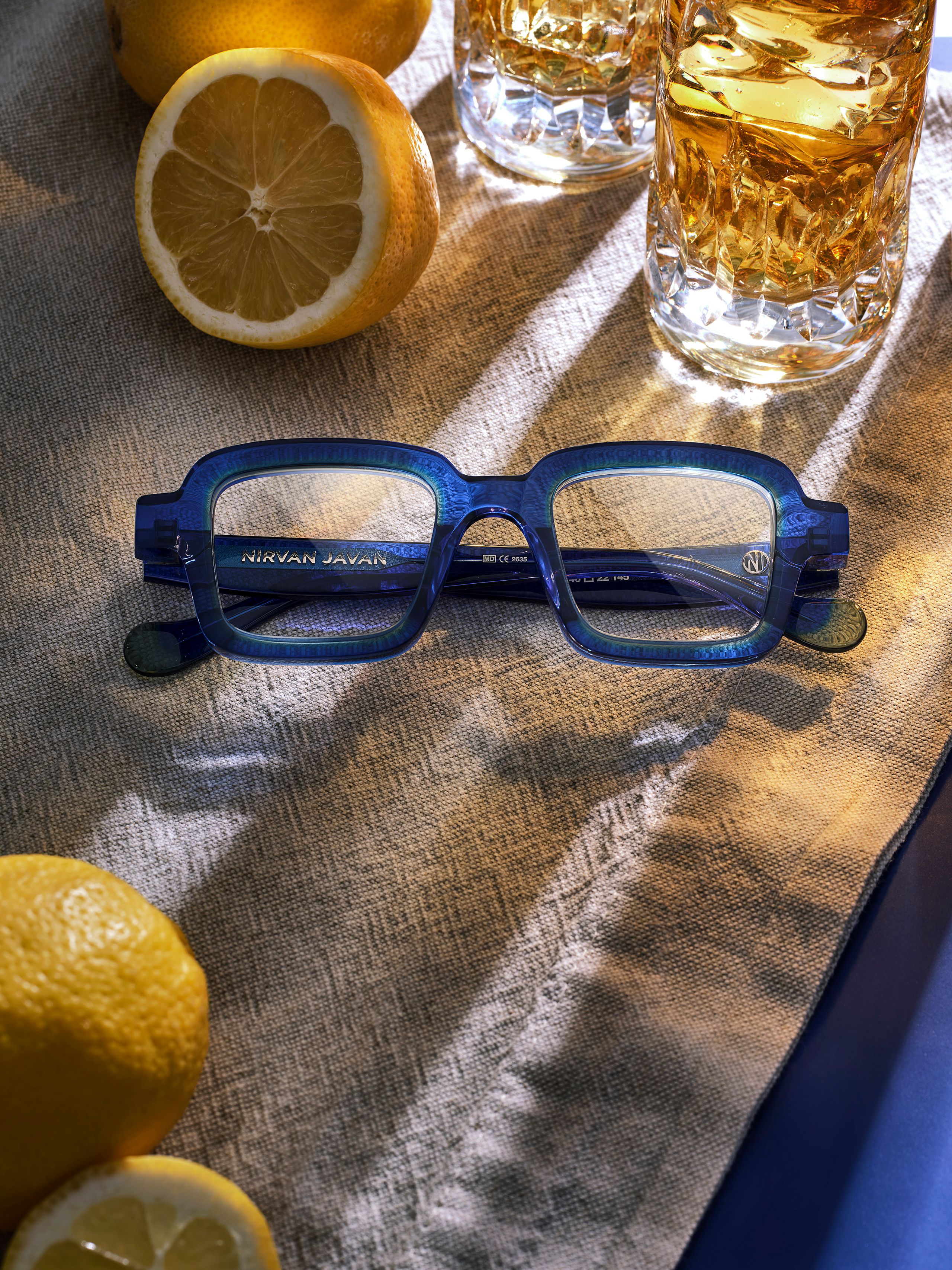 Blaue Brille mit Zitronen und bernsteinfarbenen Getränken