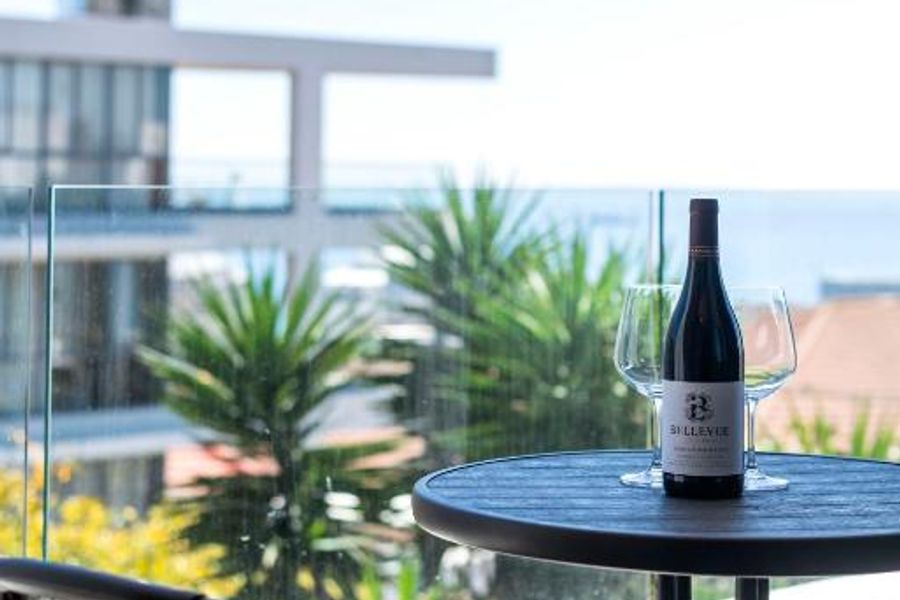 Balkon van appartement Atlantic Breeze met tafel, wijn en uitzicht op de Atlantische Oceaan