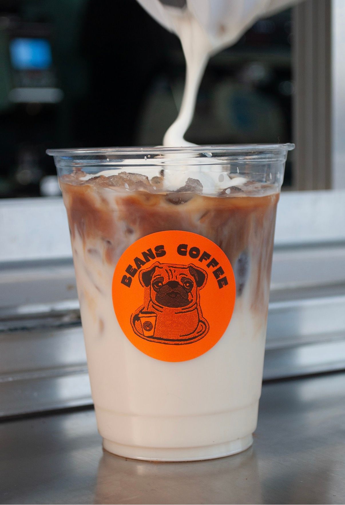 Beans Coffee latte with Beans Coffee pug sticker