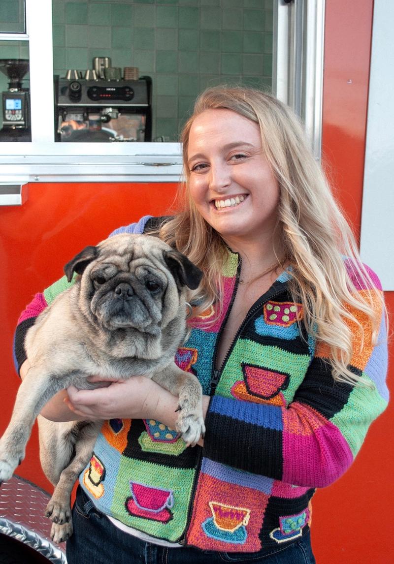 Cassidy holding the pug in from of the trailer