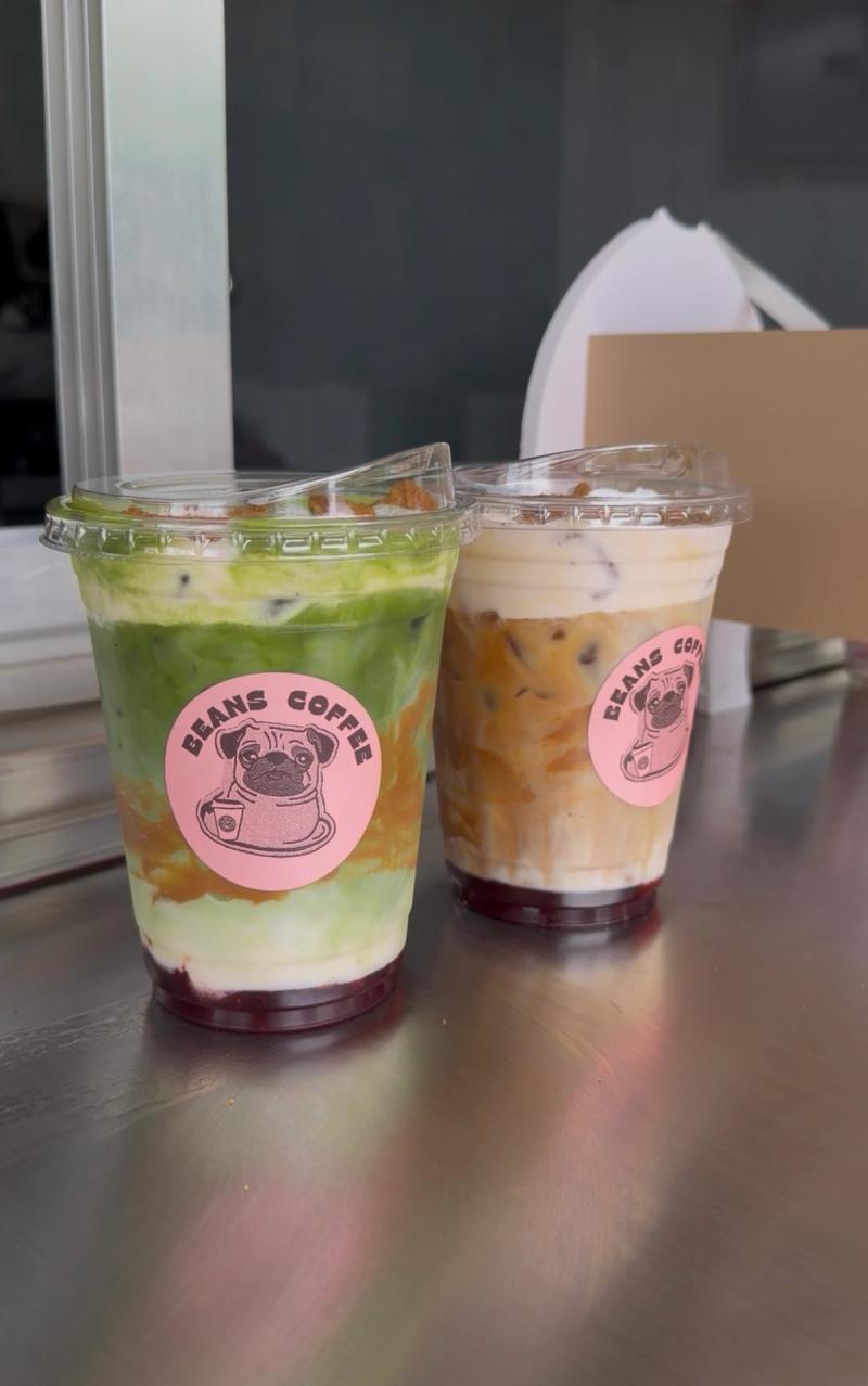 A Beans Coffee Matcha Latte and a Beans Coffee Latte with a Beans Coffee pug sticker
