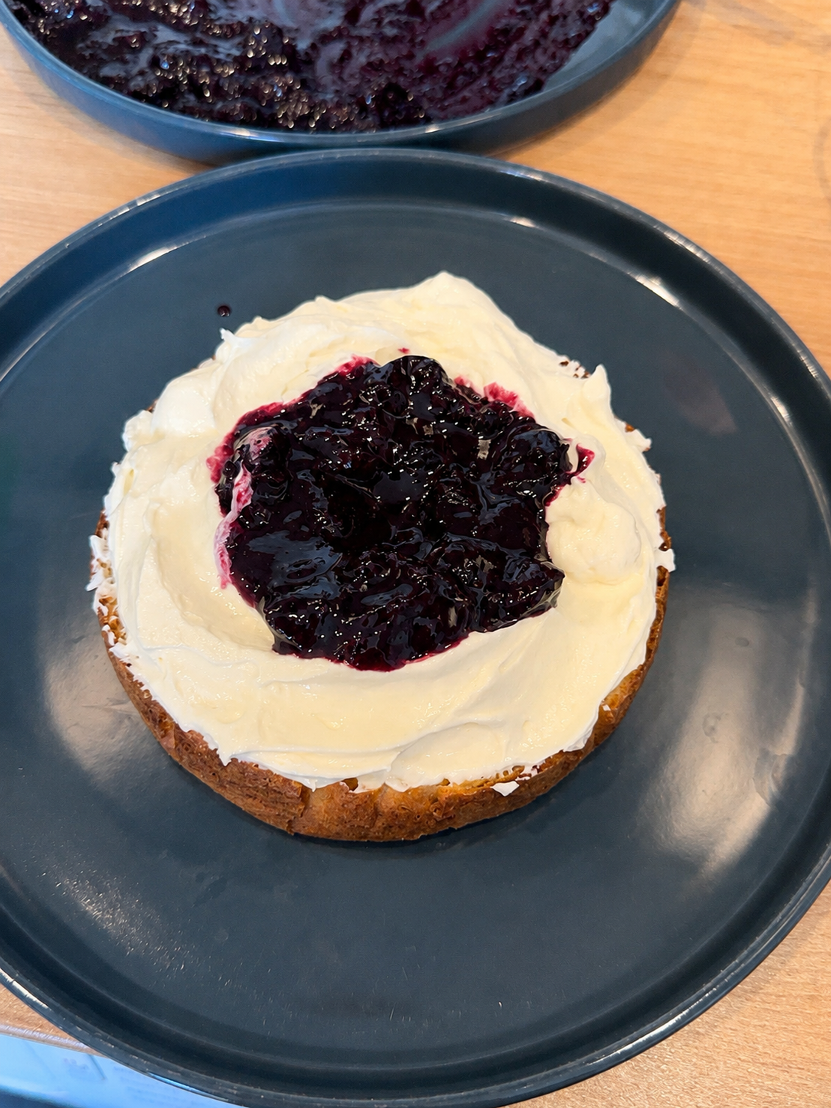 Assembling a sugar-free first birthday cake with blueberry filling and cream cheese frosting