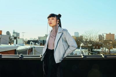 Person standing on a rooftop wearing Beats ear buds