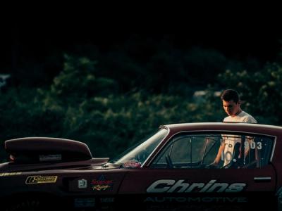 driver stands outside of his race car