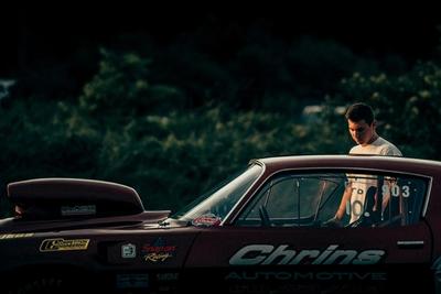A man stands next to his classic race car