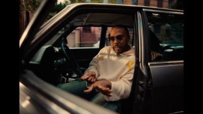 Timbaland sits in the driver seat of a car.