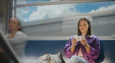Women sitting on a train using her phone