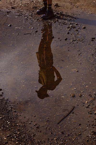 runner standing above a puddle