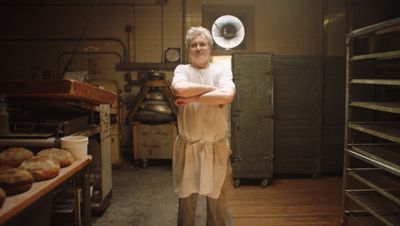 A baker stands in the morning light at his bakery in the Bronx. 